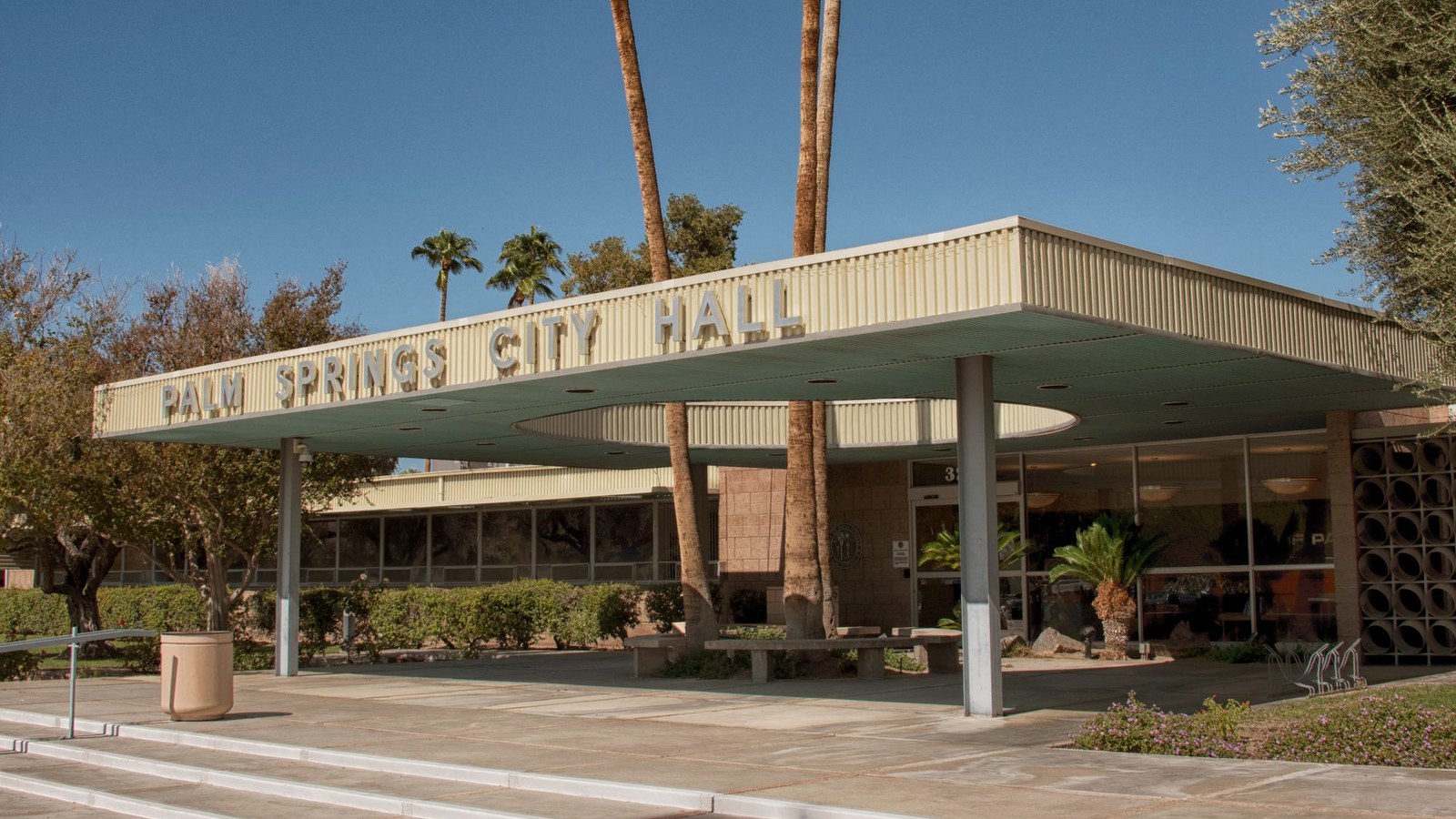 Primăria din Palm Springs, clădire modernă cu palme și copertină pe care scrie City Hall