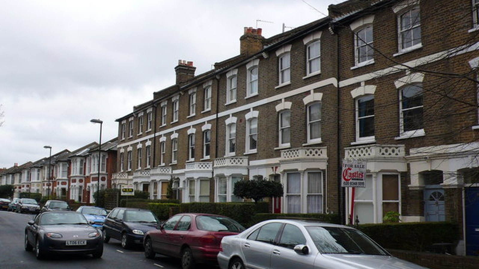 Terraced houses in north London with a For Sale board; a residential street, not a specific sale