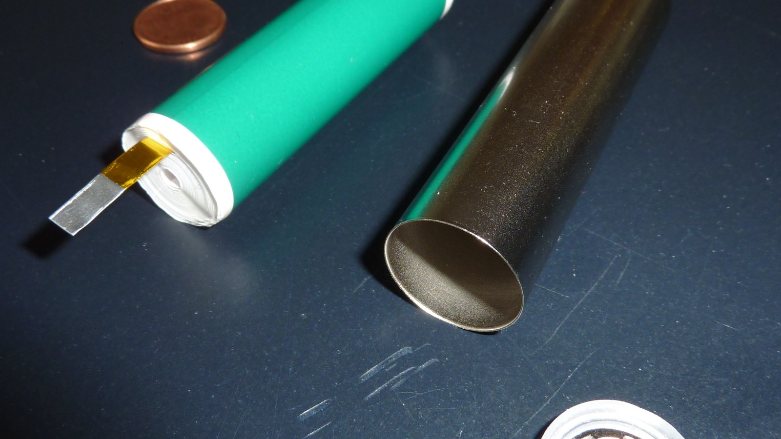 A disassembled cylindrical lithium-ion cell with the inner roll visible; not an ion diagram