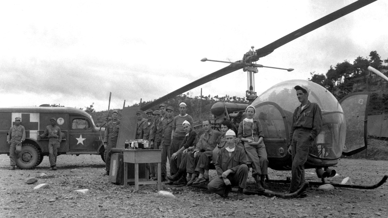 Staff of the 8225th MASH in Korea beside a Bell H-13 helicopter, 1951