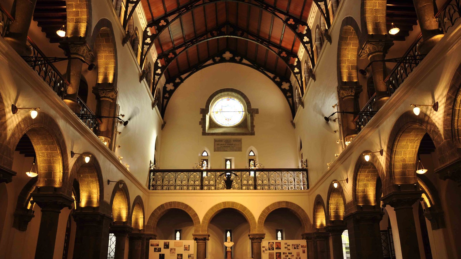 Sala principală a College of Engineering Pune, cu arcade de piatră și tavan din lemn