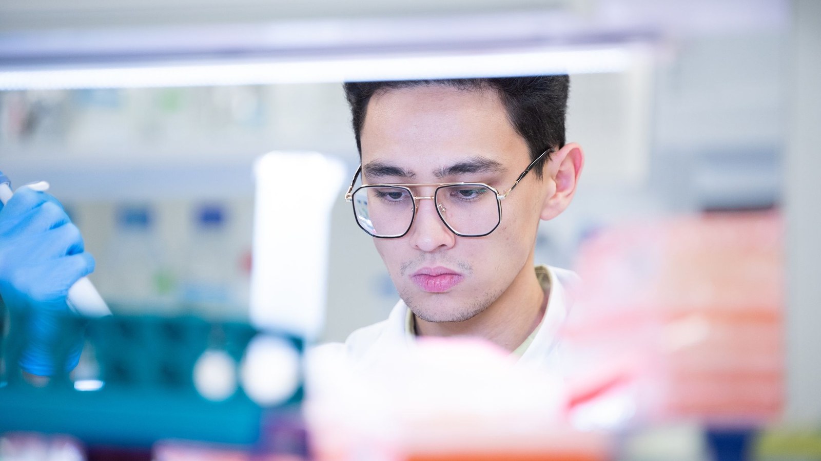 Cercetător la pipetă într-un laborator de biologie; nu sediul Anthropic