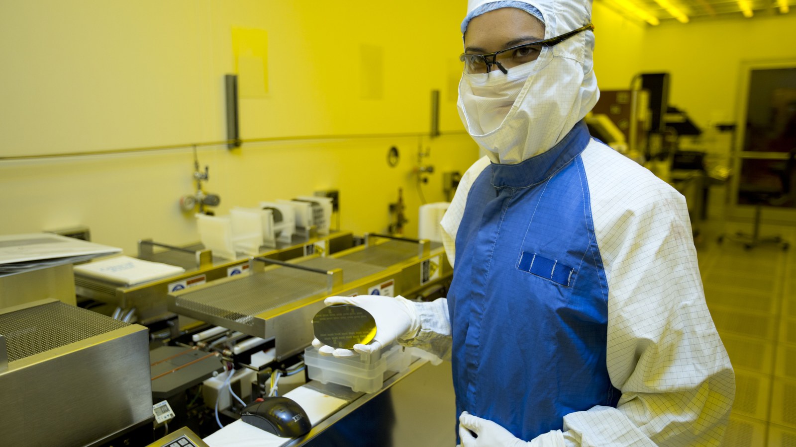 A researcher holding a silicon wafer, illustrating the semiconductor industry, not a photograph of Intel’s Ohio plant